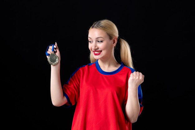 vrouwelijke basketbalspeler met gouden medaille op de zwarte achtergrond winnaar van de trofee van het atleetspel