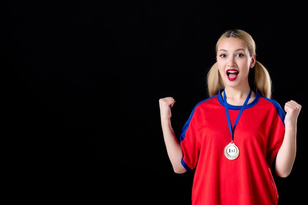 vrouwelijke basketbalspeler met gouden medaille op donkere achtergrond winnende spelatleet