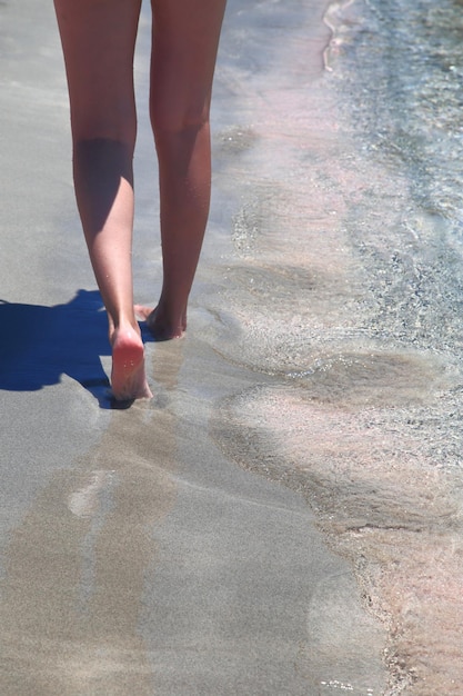 Vrouwelijke benen close-up wandelen op het zandstrand