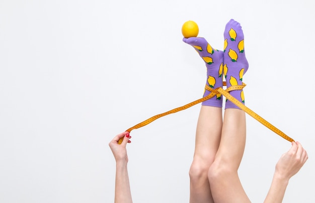 Foto vrouwelijke benen in kleurrijke sokken met citroenen geïsoleerd op een witte achtergrond