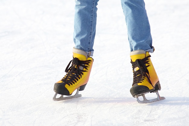 Vrouwelijke benen in schaatsen op een ijsbaan. sport, hobby's en recreatie van actieve mensen