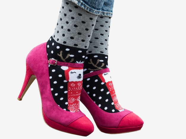 Vrouwelijke benen in stijlvolle schoenen, heldere, bont geschakeerde sokken