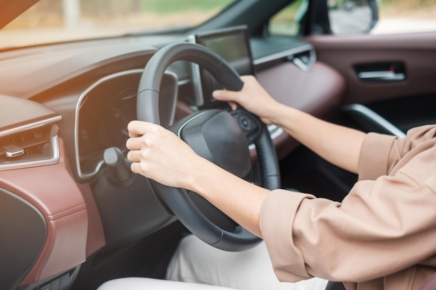 Vrouwelijke bestuurder die een auto bestuurt op de weg die het stuur in elektrische moderne auto's bestuurt Reisreis en veiligheid Transportconcepten