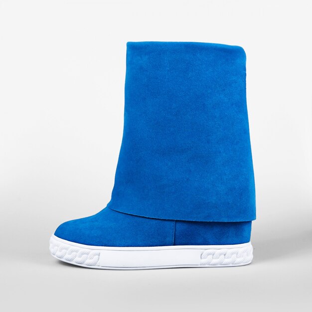 Vrouwelijke blauwe laarzen over wit