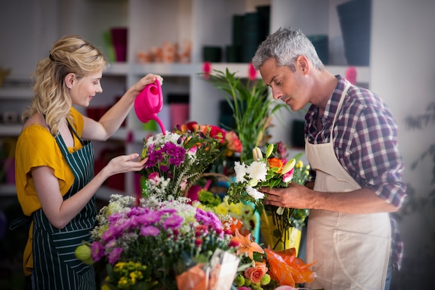 Vrouwelijke bloemist drenken bloemen