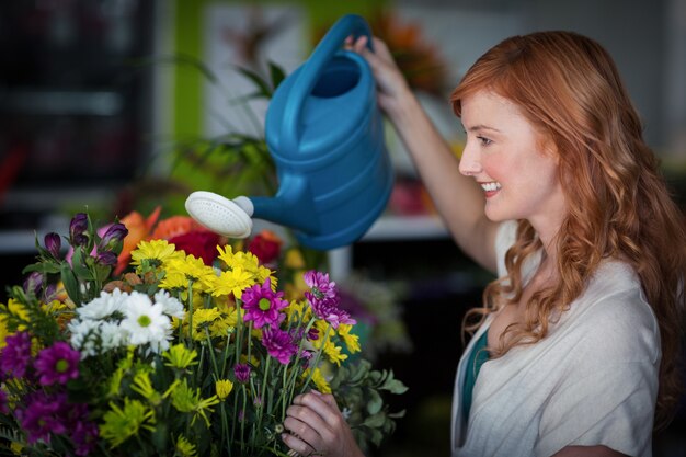 Foto vrouwelijke bloemist drenken bloemen