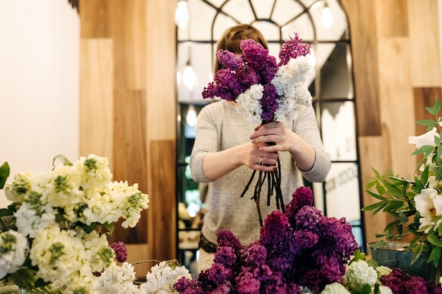 Vrouwelijke bloemist lila boeket in bloemenwinkel maken