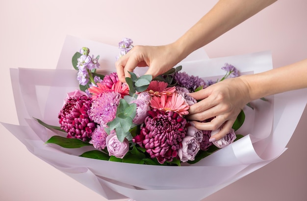 Vrouwelijke bloemist maakt boeket gemengde bloemen Levering verse snijbloem Bloemisterij workshop