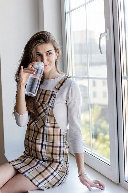 Vrouwelijke blogger drinkt water tijdens de pauze