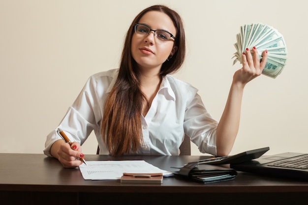 Vrouwelijke boekhouder dollars fan in haar hand te houden