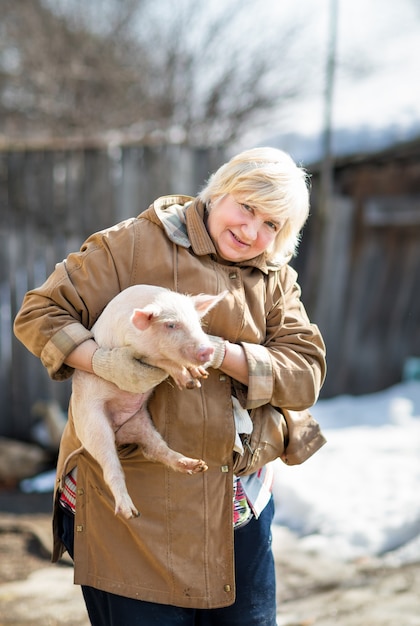 Vrouwelijke boer met een varken. Binnenlandse dieren fokken