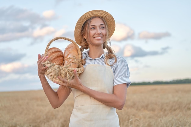 Vrouwelijke boer staande tarwe landbouwgebied Vrouw bakker bedrijf rieten mand brood product