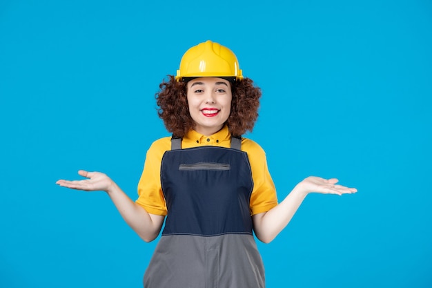 Vrouwelijke bouwer in uniform op de blauwe