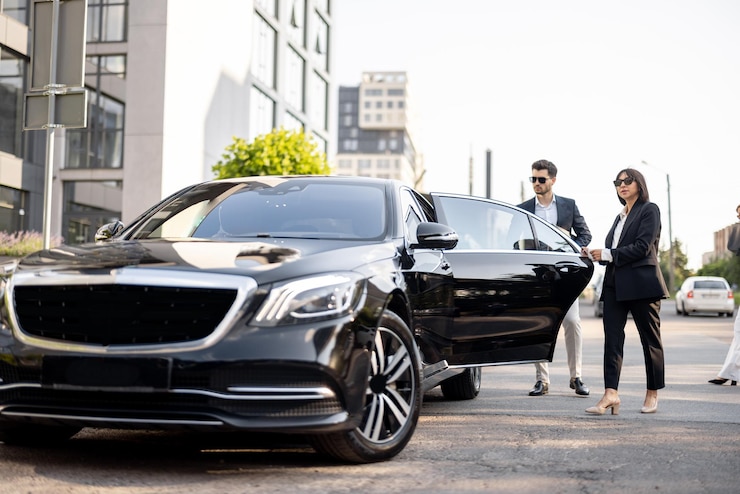 Foto vrouwelijke chauffeur helpt een zakenman uit de auto met het openen van een deur concept van persoonlijke chauffeur luxe taxi of zakenreizen