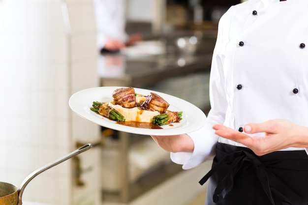 Vrouwelijke Chef-kok in restaurantkeuken het koken