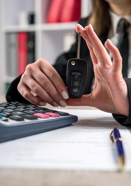 Vrouwelijke dealer geeft de autosleutels na verkoop of verhuur nieuwe klant