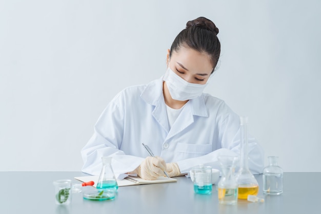 Vrouwelijke dermatoloog doet onderzoek naar nieuw huidverzorgingsproduct aan tafel, close-up