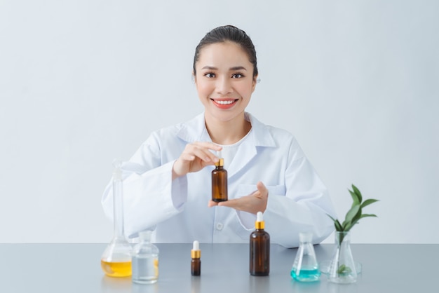 Vrouwelijke dermatoloog met fles huidverzorgingsproduct boven tafel, close-up