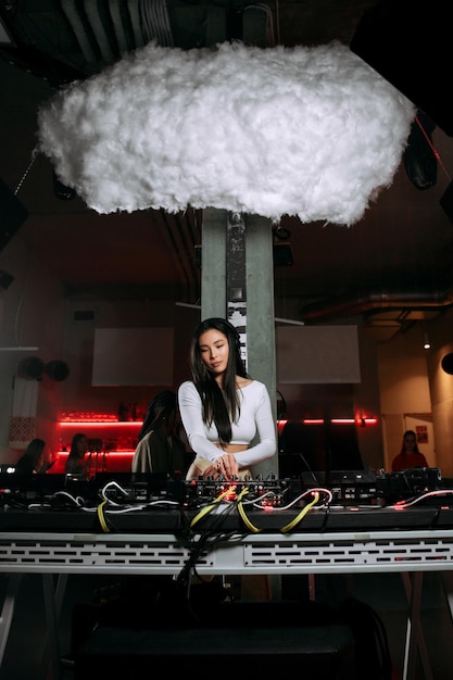 Vrouwelijke DJ speelt muziek in een nachtclub of ander evenement met behulp van DJ-apparatuur
