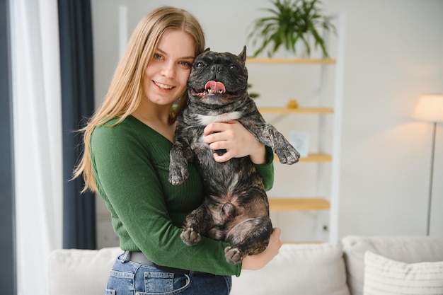 Vrouwelijke eigenaar speelt met vrolijke hond thuis spelen met hondenconcept