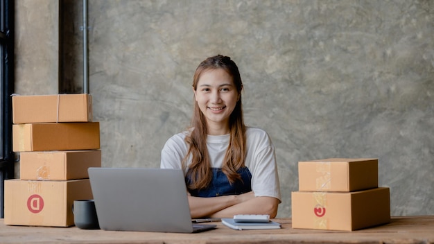 Vrouwelijke eigenaar van een startend bedrijf dat producten online verkoopt op een online winkelplatform dat goederen verzendt via een koeriersbedrijf Bedrijfsplanning Online verkoop en online winkelconcepten