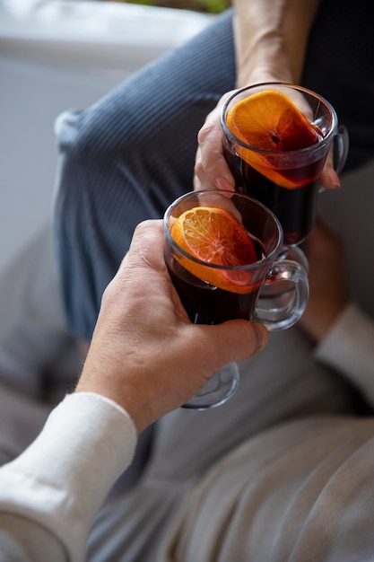 vrouwelijke en mannelijke handen met glazen glühwein