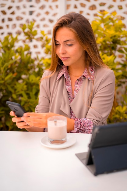 Vrouwelijke executive en zakenvrouw ontbijten in een café decaf en kijken naar e-mail