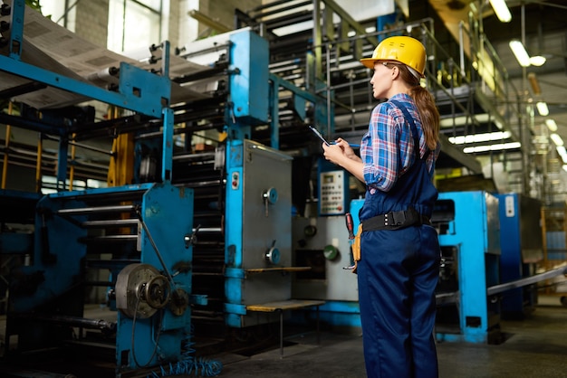 Vrouwelijke fabrieksarbeider die de kwaliteit van de productie controleert