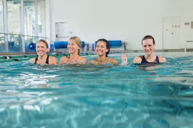 Vrouwelijke fitnessklasse die aqua-aerobics doet