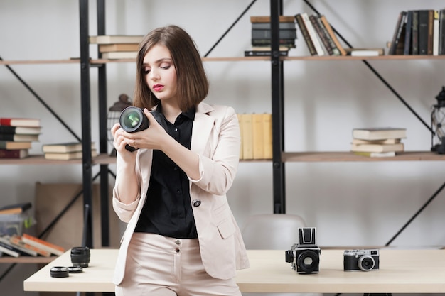 Vrouwelijke fotograaf camera kiezen voor werk.