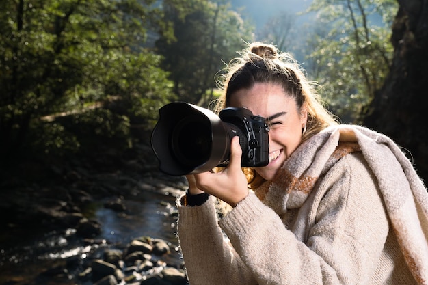 Vrouwelijke fotograaf die buiten een foto maakt naast een rivier