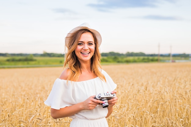 Vrouwelijke fotograaf in het veld met een camera die foto's maakt.