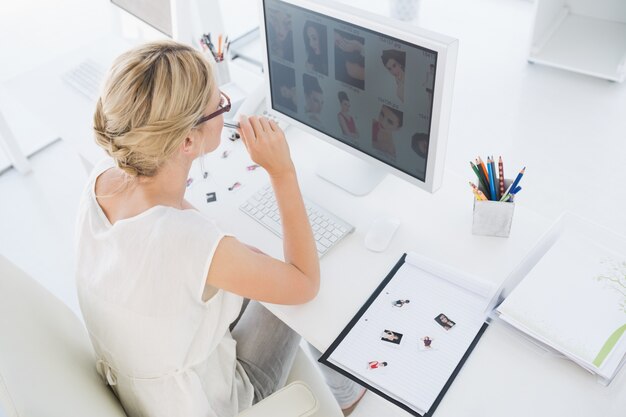 Foto vrouwelijke fotoredacteur die aan computer werkt