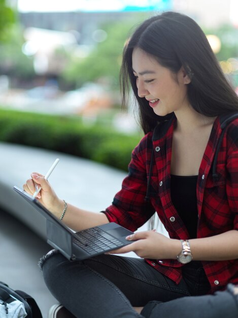 Vrouwelijke freelancer werkende tablet met stylus pen bij stadspark student ontspannen in het park