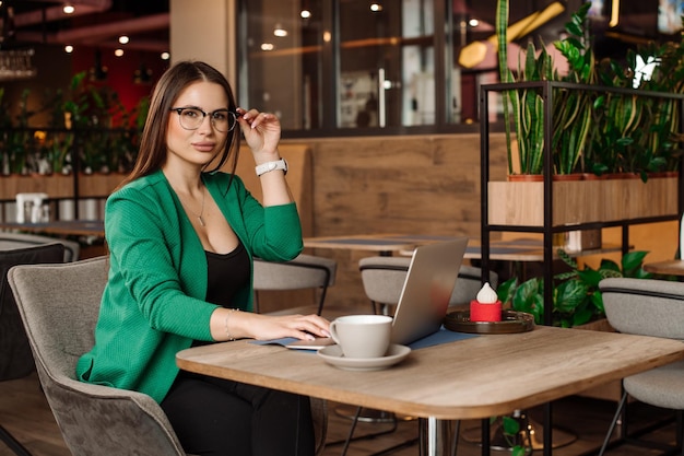 Vrouwelijke freelancer werkt met een laptop in het café of de coworking-ruimte