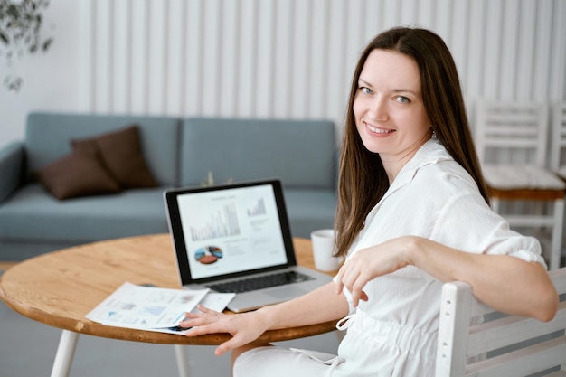 Vrouwelijke freelancer zit aan een bureau in haar thuiskantoor