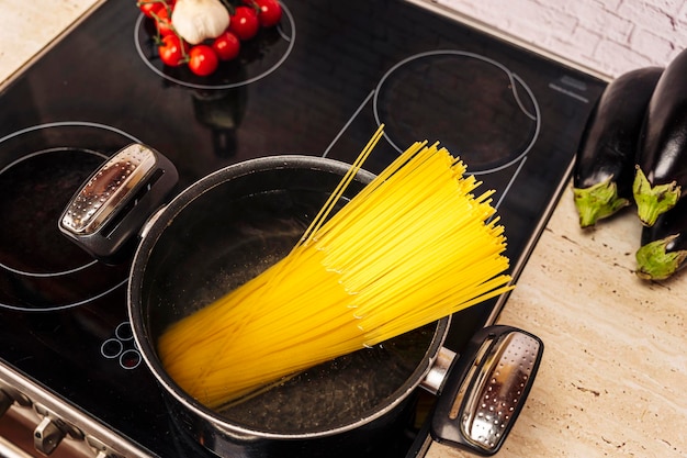 Vrouwelijke gastvrouw in de keuken kookt heerlijke spaghetti