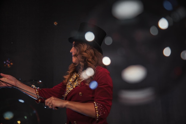 Vrouwelijke goochelaar maakt met zeepbellen een illusionist