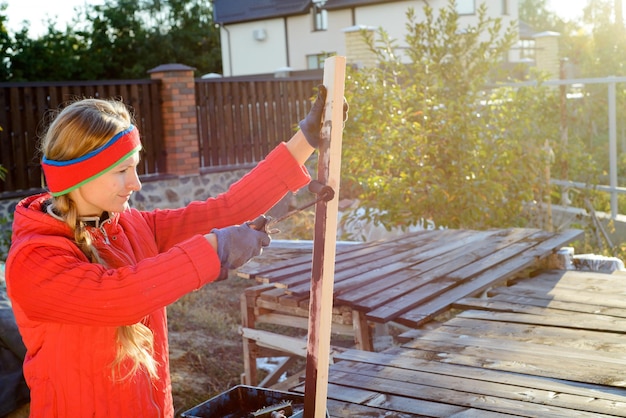 Vrouwelijke hand die hout schildert met verfroller