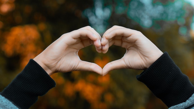 Foto vrouwelijke hand die liefdesvorm maakt