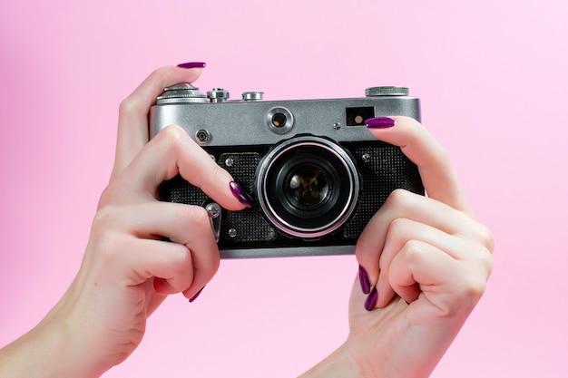 Vrouwelijke hand en camera op roze achtergrond