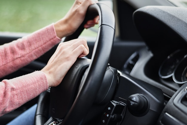 Vrouwelijke hand gedrukt claxon tijdens het rijden van de auto