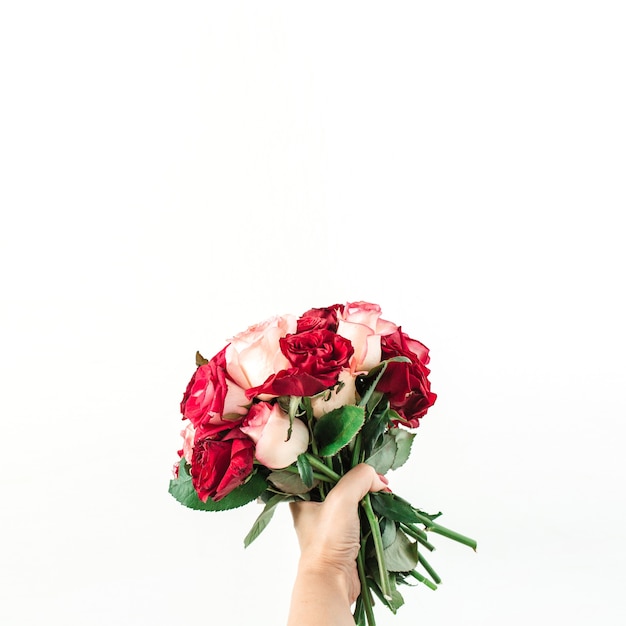 Vrouwelijke hand houden roze en rood roze bloemen boeket geïsoleerd op wit