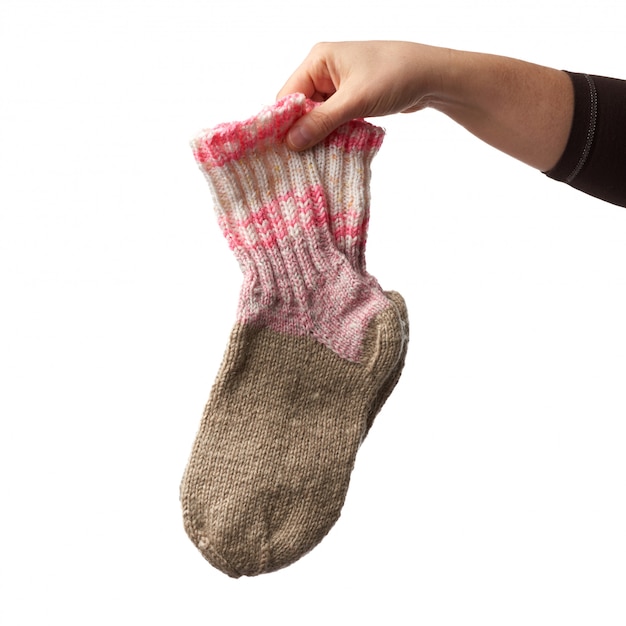 Vrouwelijke hand houdt een paar gebreide wollen sokken