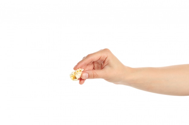 Vrouwelijke hand houdt popcorn, op wit