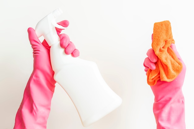 vrouwelijke hand in roze handschoenen schoonmaken op effen kleur achtergrond, huishoudelijk werk.