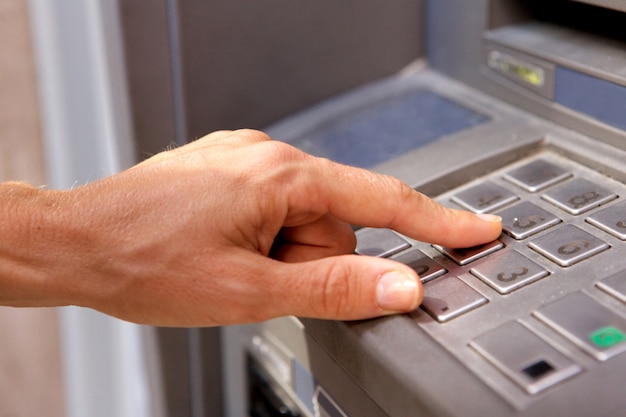 Vrouwelijke hand met bank machine toetsenbord