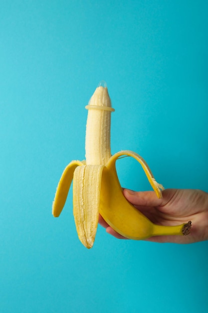 Vrouwelijke hand met condoom op een banaan Veilig seksconcept