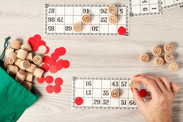 Vrouwelijke hand met een houten vat voor een spel in lotto