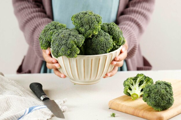 Vrouwelijke hand met een kom broccoli